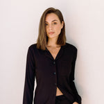 Woman wearing long ribbed modal pyjamas in black against white background