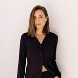 Woman wearing long ribbed modal pyjamas in black against white background